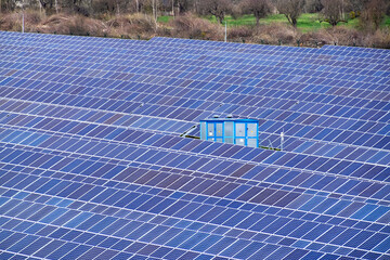 Solar power plant in the countryside in spring. Large field covered with solar panels