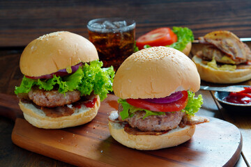 Pork Burger and Bacon  close up on a wooden cutting board , Tomatoes, lettuce, home made.