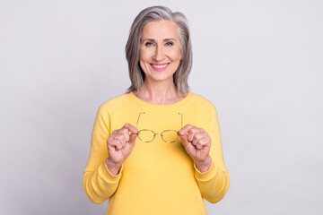 Sticker - Photo of happy good mood cheerful mature beautiful woman hold glasses wear yellow pullover isolated on grey color background