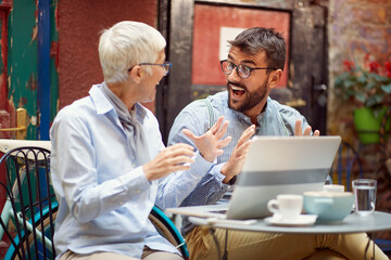 Wall Mural - An elderly woman has an interesting talk with her young male friend while spending free time at bar's garden together. Leisure, bar, friendship, outdoor