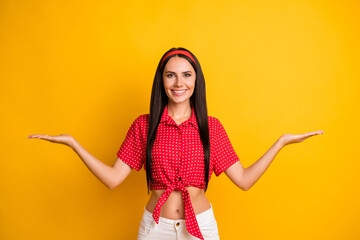 Poster - Portrait of charming cheerful girl holding on palms two options vs ad isolated over bright yellow color background