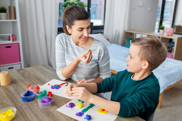 Canvas Print - family, creativity and craft concept - mother and little son making picture of modeling clay at home