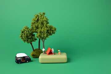 Canvas Print - Miniature people with tent, tree and camper on green backdrop. Minimal camping concept. Family outdoor activity.