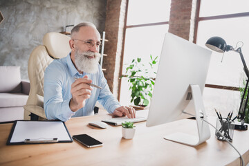 Photo of happy cheerful cool businessman old gut look computer hold pen smile indoors inside office workplace