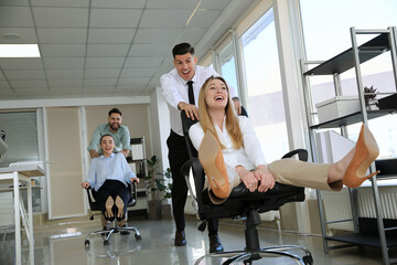 Sticker - Happy office employees riding chairs at workplace