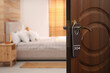 © New Africa - Wooden door open into modern hotel room, closeup