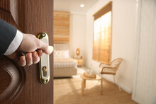 Man Opening Wooden Door To Hotel Room, Closeup