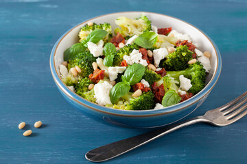 Wall Mural - healthy broccoli salad with feta cheese sun dried tomatoes pine nuts.. vegetarian low carb keto diet