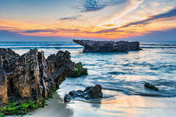 Wall Mural - Smoky sky sunset, flowing water over rocks, at Trigg Beach, Perth West Australia