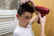 © Minet - Boy dries hair the hair dryer.