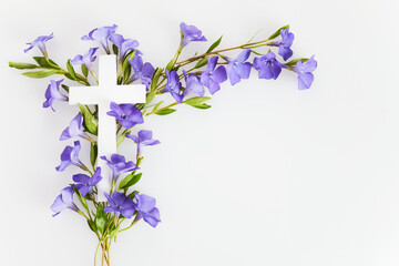 Wall Mural - The Christianity cross of beautiful blue periwinkle flower. Baptism, Easter, church holiday background