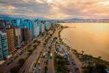 Fototapeta Londyn - aerial image with drone on the seashore at sunset in florianópolis Santa Catarina with the ferris wheel