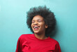 © olly - young black woman laughing on a ble background