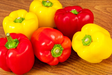 Wall Mural - Red and yellow peppers on a brown wooden table