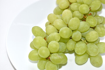 A bunch of green grapes on a white plate