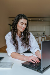 Wall Mural - Attractive young woman typing something using laptop