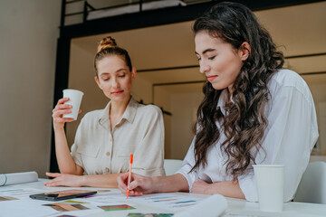 Wall Mural - Two women designers discussing new clothes models