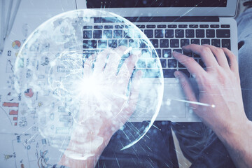 Double exposure of man's hands typing over computer keyboard and business theme hologram drawing. Top view. Financial markets concept.