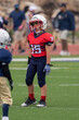 © Joe - Young athletic boy playing in a youth tackle football game