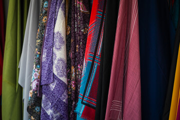 Close-up rows of pieces of fabric made of cotton, polyester, tapestry and other materials of different colors and prints for sewing curtains, handkerchiefs and clothing