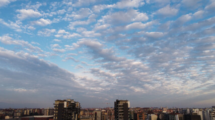 Panoramic shot of a city skyline under a cloudy blue sky