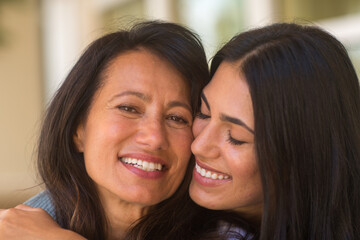 Mother and her adult daughter hugging and laughing