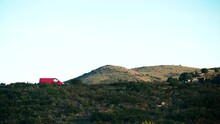 Red Camper Van Camping On Nature, In Punta Falconera Hilly Green Landscape. Province Girona, North Of Catalonia, Spain.