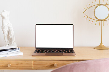 Wall Mural - Laptop with blank white screen on the office table in home scandi interior. Stylish minimal workplace, copy space