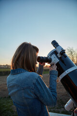 Wall Mural - woman looking at night sky with amateur astronomical telescope.