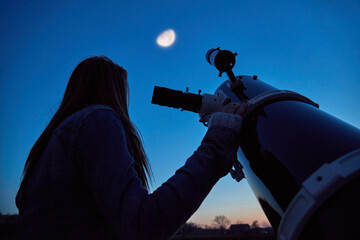 Wall Mural - woman looking at night sky with amateur astronomical telescope.