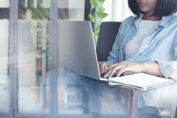 Wall Mural - Casual business woman online working on laptop computer in coffee shop