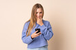 © luismolinero - Teenager Ukrainian girl isolated on beige background thinking and sending a message