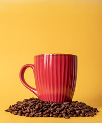 Poster - Closeup shot of a cup of hot coffee and coffee beans isolated on a yellow surface