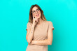 © luismolinero - Young caucasian woman isolated on blue background thinking an idea while looking up