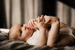 © Ananass - happy child lying on the bed and holding his legs