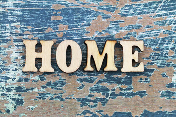 Wall Mural - Word home written with colorful wooden letters on rustic wooden surface and colorful flowers
