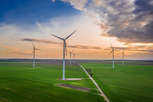 Wind Turbines At Dusk On Green Field. Renewable Energy, Poland.
