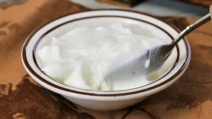 Canvas Print - Eating a spoonful of yogurt in super slow motion