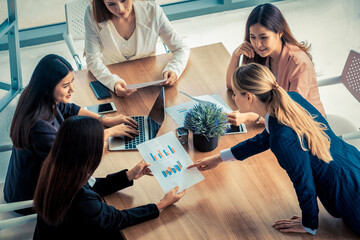 Wall Mural - Businesswoman in group meeting discussion with other businesswomen colleagues in modern workplace office with laptop computer and documents on table. People corporate business working team concept.