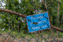 A Private Property Keep Out Sign On Some Mesh Fencing 