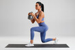 © nikolas_jkd - Fitness woman doing lunges exercises with kettlebell, leg muscle training. Active girl doing front forward one leg step lunge