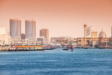 Wall Mural - Scenic view of Dubai Creek district with skyscrapers, Dhow cruise boats and mosque minarets. Famous old district of the city attracts numerous tourists and authentic travelers