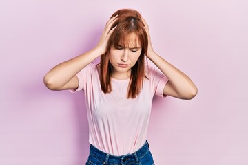 Canvas Print - Redhead young woman wearing casual pink t shirt suffering from headache desperate and stressed because pain and migraine. hands on head.