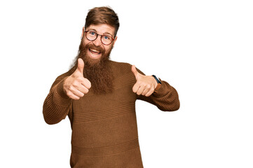 Young irish redhead man wearing casual clothes and glasses approving doing positive gesture with hand, thumbs up smiling and happy for success. winner gesture.