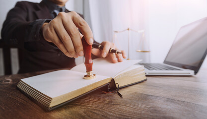 Justice and law concept.Male judge in a courtroom with the gavel, working with, computer and docking keyboard, eyeglasses, on table in morning light