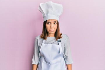 Sticker - Young beautiful woman wearing professional cook uniform and hat depressed and worry for distress, crying angry and afraid. sad expression.