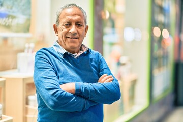 Wall Mural - senior grey-haired man with arms crossed smiling happy standing at the city.