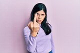 Young hispanic woman wearing casual clothes showing middle finger, impolite and rude fuck off expression