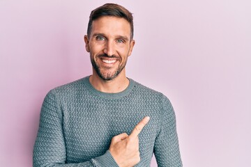 Sticker - Handsome man with beard wearing casual winter sweater smiling cheerful pointing with hand and finger up to the side