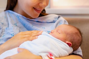 A happy mother holding her newborn baby after giving birth in the hospital.